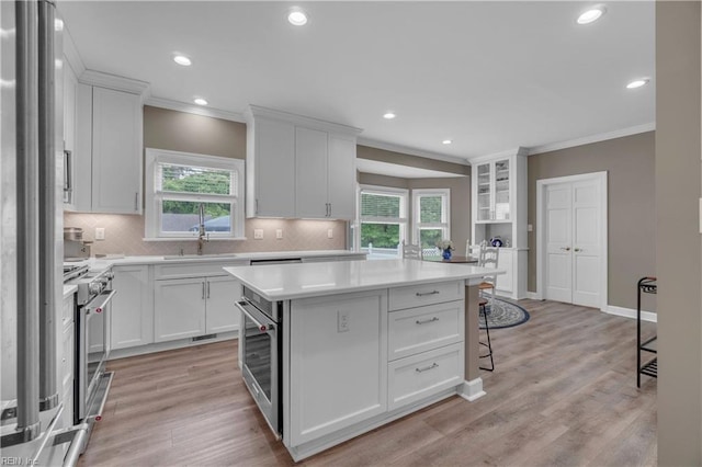 136 Wynnwood Dr, Franklin, VA 23851 - kitchen with ornamental molding, a center island, backsplash, stainless steel appliances, and light countertops