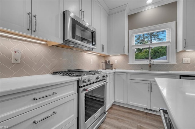 136 Wynnwood Dr, Franklin, VA 23851 - kitchen featuring stainless steel appliances, a sink, light countertops, decorative backsplash, and white cabinets