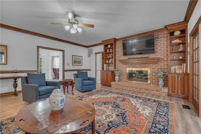 136 Wynnwood Dr, Franklin, VA 23851 - living area with light wood-style floors, ceiling fan, built in features, a brick fireplace, and ornamental molding