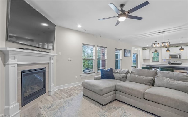 126 Secretariat Dr, Suffolk, VA 23435 - living room with light wood finished floors, a glass covered fireplace, a ceiling fan, baseboards, and recessed lighting