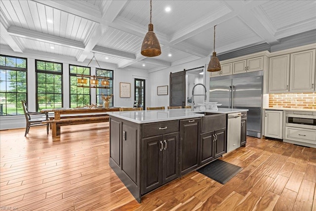 107 Gullane, Smithfield, VA 23430 - kitchen featuring a barn door, light wood-style floors, stainless steel appliances, light countertops, and a sink
