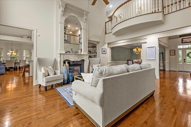 201 Royal Dornoch, Smithfield, VA 23430 - living room with a towering ceiling, a chandelier, wood finished floors, built in shelves, and a glass covered fireplace