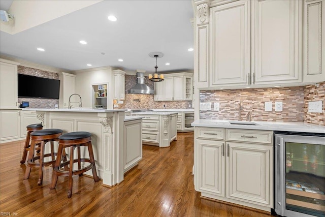 201 Royal Dornoch, Smithfield, VA 23430 - kitchen with wine cooler, wall chimney exhaust hood, a sink, a center island with sink, and light countertops