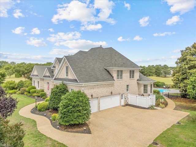 201 Royal Dornoch, Smithfield, VA 23430 - view of property exterior featuring driveway, an attached garage, a shingled roof, and brick siding