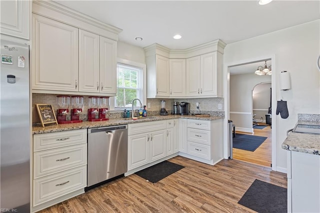 133 Chesterfield Rd, Hampton, VA 23661 - kitchen featuring appliances with stainless steel finishes, a sink, light wood-style flooring, decorative backsplash, and white cabinets