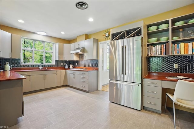 6076 Newport Pt, Norfolk, VA 23505 - kitchen featuring stainless steel appliances, under cabinet range hood, a sink, dark countertops, and backsplash