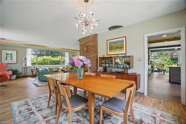 6076 Newport Pt, Norfolk, VA 23505 - dining room with plenty of natural light, light wood-style flooring, a chandelier, a textured ceiling, and baseboards