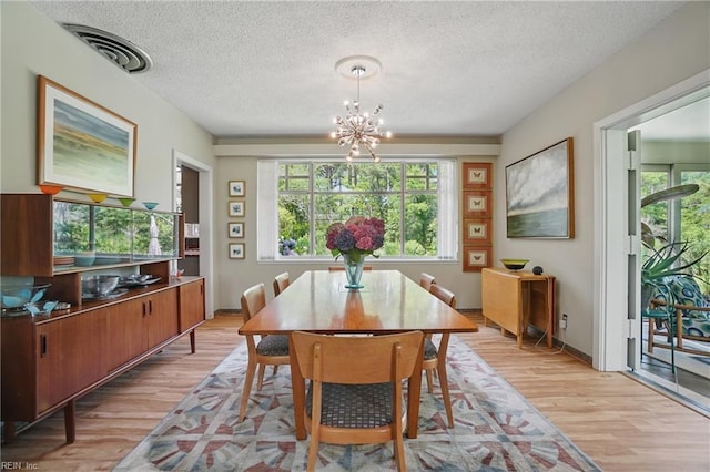 6076 Newport Pt, Norfolk, VA 23505 - dining room with light wood finished floors, a chandelier, healthy amount of natural light, and a textured ceiling