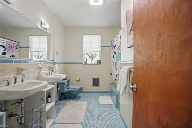 6076 Newport Pt, Norfolk, VA 23505 - full bathroom with tile walls, toilet, a sink, shower / tub combo, and a wainscoted wall