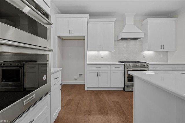 206 84th St Unit A, Virginia Beach, VA 23451 - kitchen featuring stainless steel range with gas cooktop, premium range hood, white cabinetry, dark wood-type flooring, and backsplash