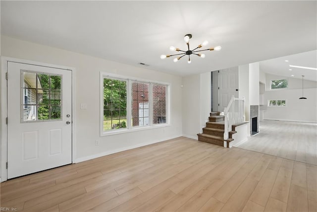 1202 Land St, Norfolk, VA 23502 - unfurnished living room with a chandelier, light wood finished floors, stairway, baseboards, and vaulted ceiling