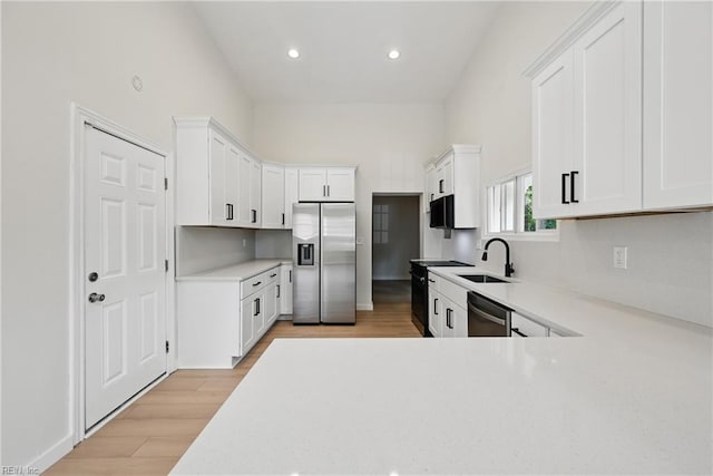 1202 Land St, Norfolk, VA 23502 - kitchen featuring black appliances, a sink, light countertops, light wood finished floors, and white cabinetry