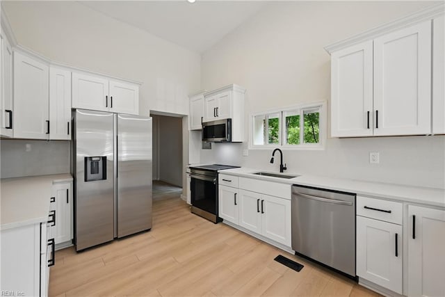1202 Land St, Norfolk, VA 23502 - kitchen with appliances with stainless steel finishes, a sink, light countertops, white cabinets, and light wood-type flooring