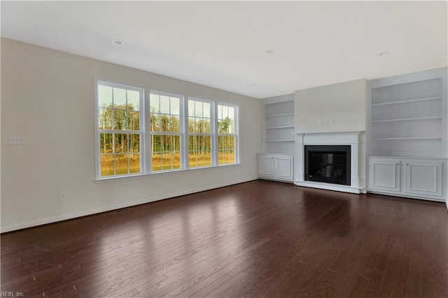 2221 Patrick Dr, Suffolk, VA 23435 - unfurnished living room with dark wood-style flooring, built in features, baseboards, and a glass covered fireplace