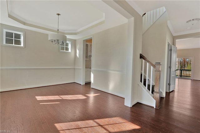 2221 Patrick Dr, Suffolk, VA 23435 - unfurnished dining area featuring dark wood-style floors, a chandelier, stairs, a raised ceiling, and ornamental molding