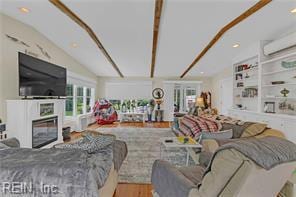 96 Doctors Creek Rd, New Point, VA 23125 - living area featuring wood finished floors, vaulted ceiling, a fireplace, and a wall unit AC