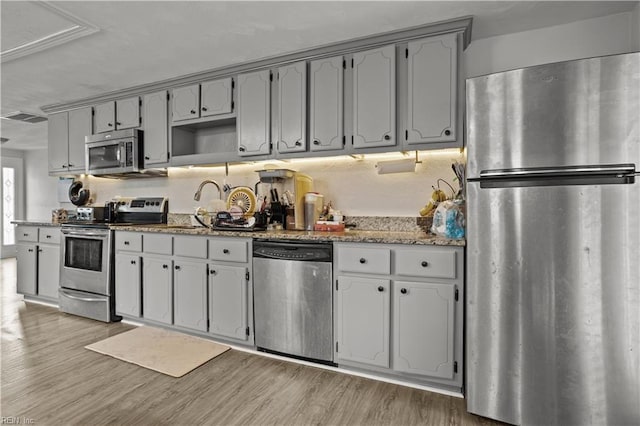 1201 Hale Dr, Hampton, VA 23663 - kitchen with appliances with stainless steel finishes, light wood finished floors, gray cabinets, light stone counters, and a sink