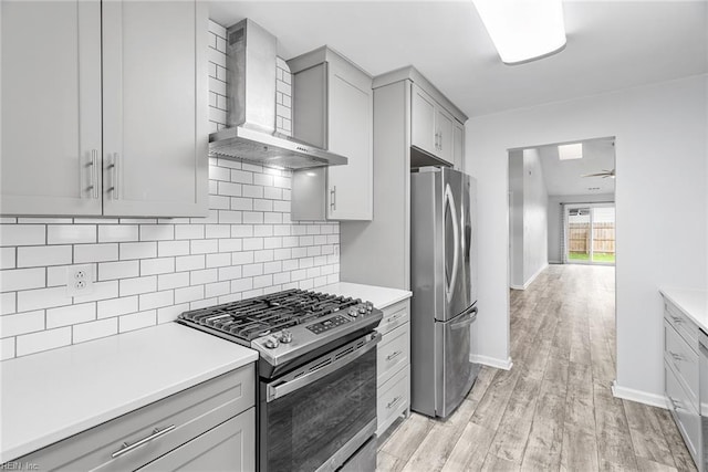 1016 Gauguin Dr, Virginia Beach, VA 23454 - kitchen featuring stainless steel appliances, wall chimney range hood, gray cabinets, decorative backsplash, and light wood finished floors