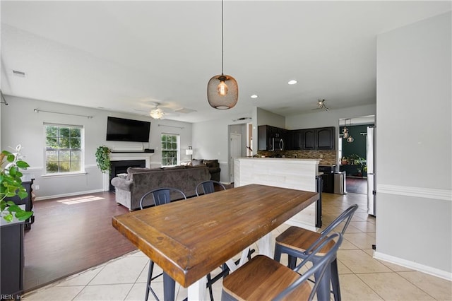 3507 Sedgefield St, Suffolk, VA 23435 - dining room featuring light tile patterned floors, ceiling fan, a fireplace, baseboards, and recessed lighting