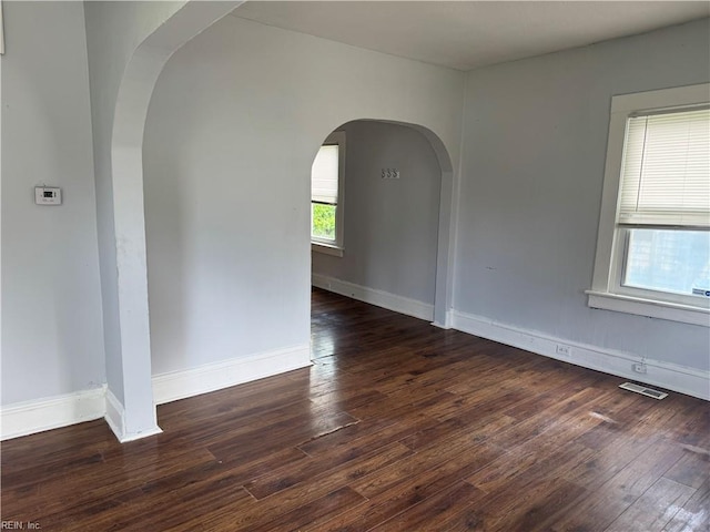 215 E Howard St, Hampton, VA 23663 - spare room featuring arched walkways, hardwood / wood-style floors, and baseboards