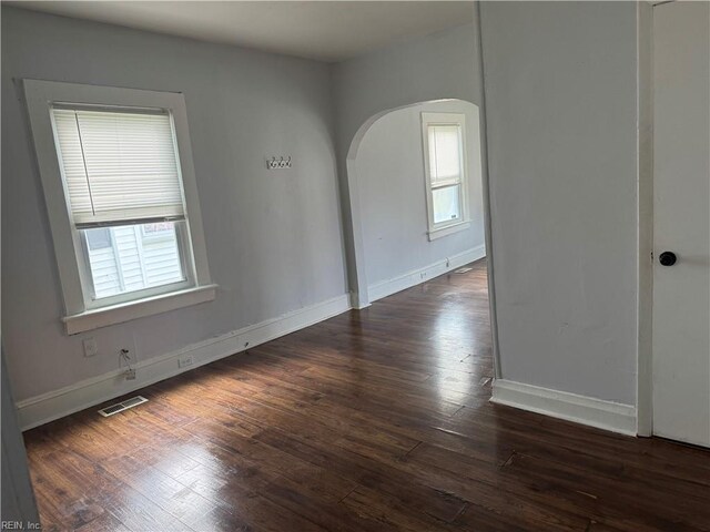 215 E Howard St, Hampton, VA 23663 - spare room featuring arched walkways, dark wood-style flooring, and baseboards