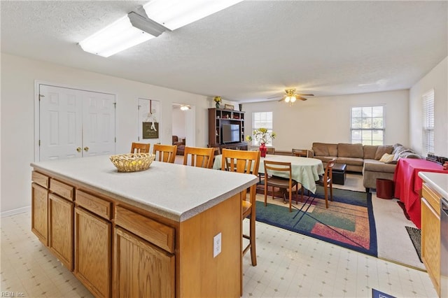 103 Barcroft Dr, Smithfield, VA 23430 - kitchen with light flooring, a textured ceiling, a center island, a breakfast bar area, and a ceiling fan