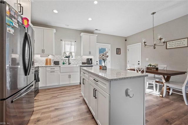 554 Trotman Rd, Camden, NC 27921 - kitchen featuring freestanding refrigerator, a chandelier, a sink, decorative backsplash, and a center island