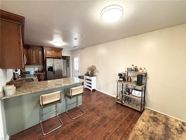 1135 Virginia Ave, Chesapeake, VA 23324 - kitchen featuring appliances with stainless steel finishes, a peninsula, dark wood finished floors, a kitchen breakfast bar, and light stone counters