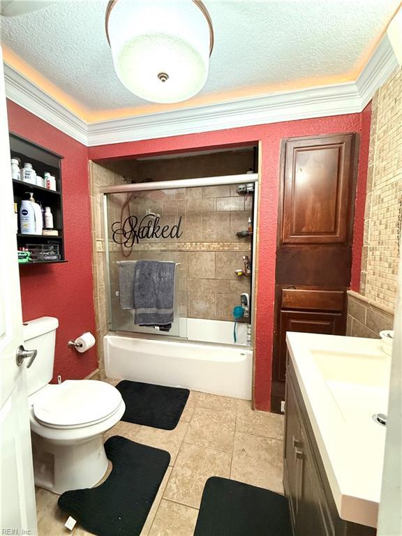 138 Ransone St, Hampton, VA 23669 - bathroom featuring a textured ceiling, ornamental molding, vanity, tile patterned floors, and enclosed tub / shower combo