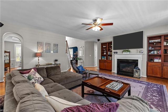 122 Merchant Man Ct, Williamsburg, VA 23185 - living area with ceiling fan, arched walkways, a fireplace with flush hearth, and wood finished floors