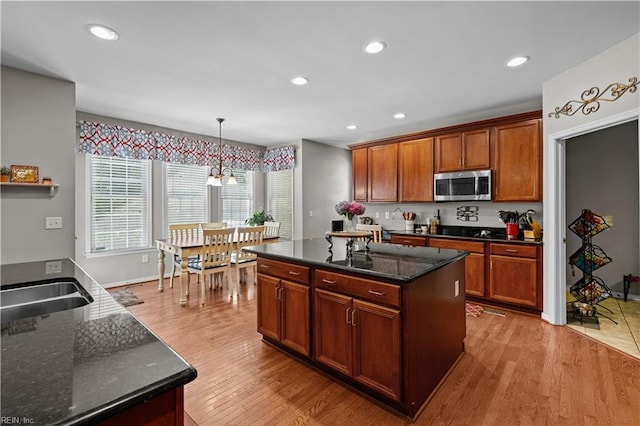 122 Merchant Man Ct, Williamsburg, VA 23185 - kitchen featuring stainless steel microwave, light wood-style floors, a chandelier, dark stone countertops, and recessed lighting