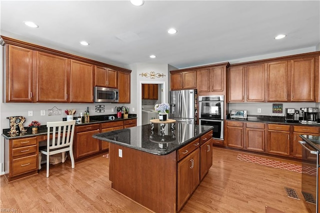 122 Merchant Man Ct, Williamsburg, VA 23185 - kitchen with appliances with stainless steel finishes, washing machine and dryer, a kitchen island, brown cabinets, and recessed lighting