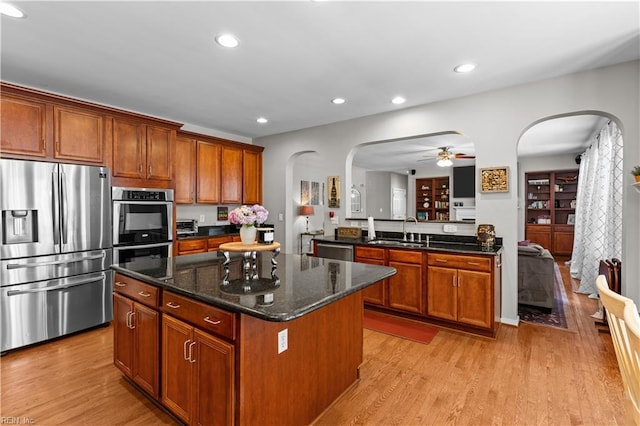 122 Merchant Man Ct, Williamsburg, VA 23185 - kitchen featuring appliances with stainless steel finishes, a sink, arched walkways, a kitchen island, and a ceiling fan