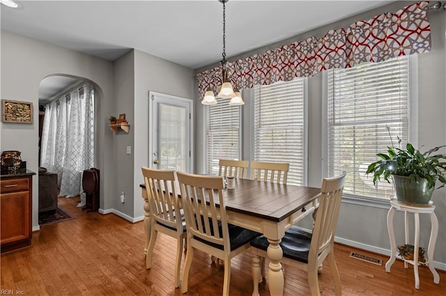 122 Merchant Man Ct, Williamsburg, VA 23185 - dining area with light wood-type flooring, baseboards, arched walkways, and a chandelier