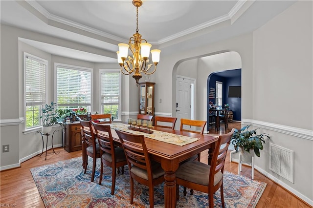 122 Merchant Man Ct, Williamsburg, VA 23185 - dining room featuring a tray ceiling, a chandelier, light wood-type flooring, arched walkways, and ornamental molding