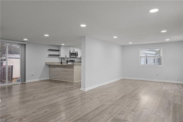 1305 Canary Dr, Virginia Beach, VA 23453 - unfurnished living room with light wood finished floors, baseboards, recessed lighting, and a sink