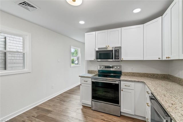 436 Smiley Rd, Hampton, VA 23663 - kitchen with appliances with stainless steel finishes, white cabinets, light wood-style flooring, recessed lighting, and light stone countertops
