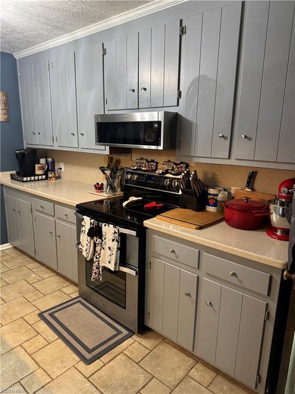 412 Joseph Topping Dr, Poquoson, VA 23662 - kitchen featuring appliances with stainless steel finishes, a textured ceiling, light countertops, gray cabinets, and crown molding