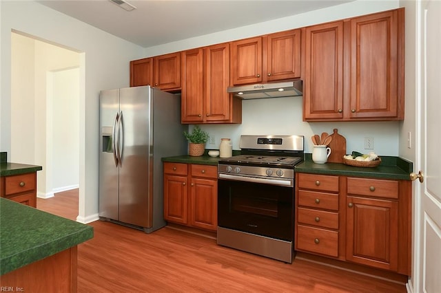 735 Great Marsh Ave, Chesapeake, VA 23320 - kitchen featuring stainless steel appliances, under cabinet range hood, dark countertops, light wood-style flooring, and brown cabinets