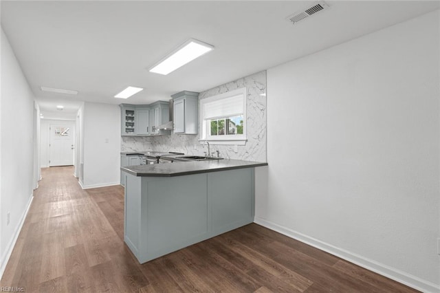 1304 Quash St, Hampton, VA 23669 - kitchen with gray cabinetry, a sink, wood finished floors, glass insert cabinets, and backsplash