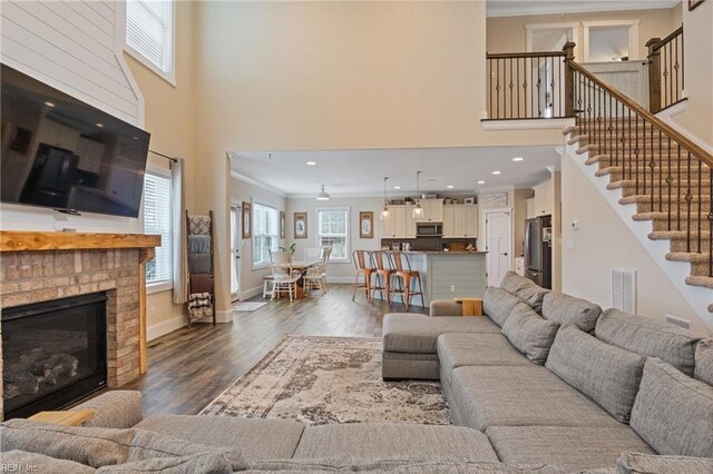 115 Cooks Landing Rd, Camden, NC 27921 - living room with ornamental molding, a fireplace, stairway, dark wood-style floors, and a towering ceiling