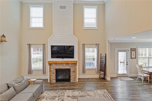115 Cooks Landing Rd, Camden, NC 27921 - living room with crown molding, wood finished floors, a brick fireplace, a high ceiling, and baseboards