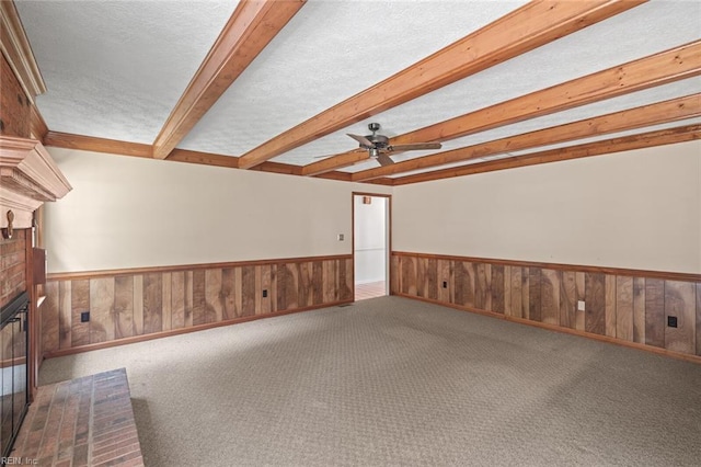 1118 Patrick Ln, Newport News, VA 23608 - unfurnished room featuring a ceiling fan, beam ceiling, a brick fireplace, wainscoting, and a textured ceiling