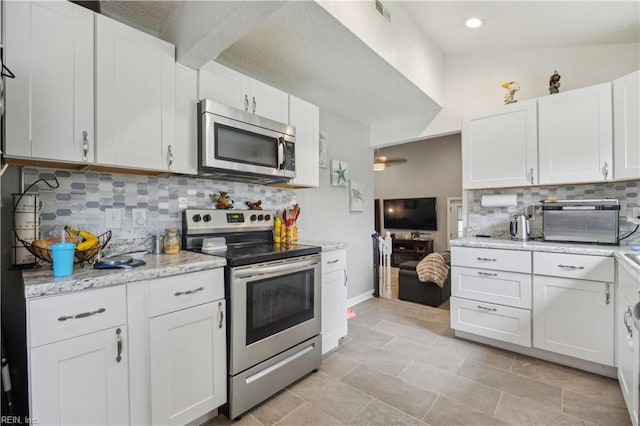 1014 Rowe St, Hampton, VA 23669 - kitchen featuring appliances with stainless steel finishes, tasteful backsplash, white cabinets, light stone countertops, and baseboards