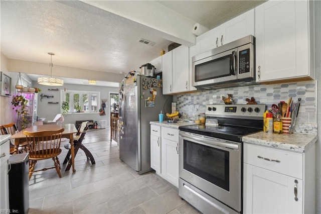 1014 Rowe St, Hampton, VA 23669 - kitchen featuring stainless steel appliances, decorative backsplash, white cabinetry, decorative light fixtures, and a textured ceiling