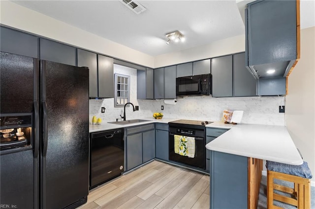 1107 Ocean Pebbles Way, Virginia Beach, VA 23451 - kitchen with black appliances, a sink, light wood-type flooring, backsplash, and light countertops