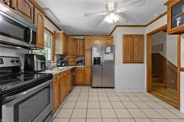 119 Waltham St, Hampton, VA 23666 - kitchen featuring stainless steel appliances, a sink, ceiling fan, brown cabinetry, and a wainscoted wall