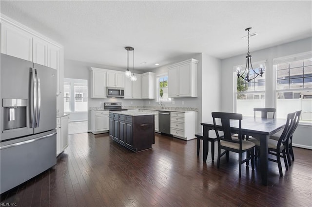 2209 Beeblossom Ln, Chesapeake, VA 23323 - kitchen featuring stainless steel appliances, a chandelier, dark wood-style flooring, white cabinetry, and a center island