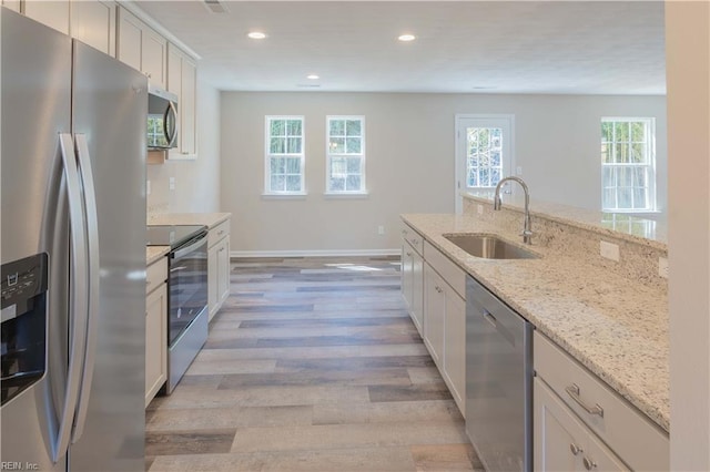 2807 Eustis Ave, Chesapeake, VA 23325 - kitchen featuring appliances with stainless steel finishes, a sink, light wood-style flooring, light stone countertops, and recessed lighting