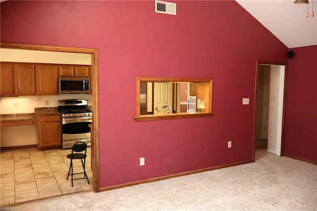 1314 Hunningdon Woods Blvd, Chesapeake, VA 23320 - kitchen featuring stainless steel appliances, brown cabinets, high vaulted ceiling, and light carpet